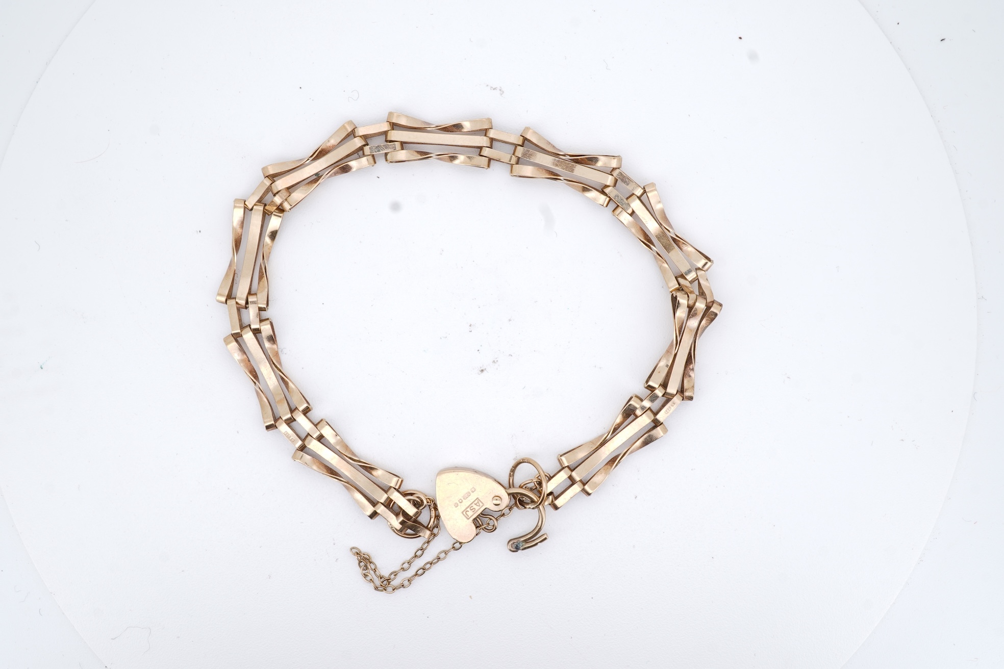 A 1980's 9ct gold gate link bracelet, with heart shaped padlock clasp, approx. 18cm, 5 grams.